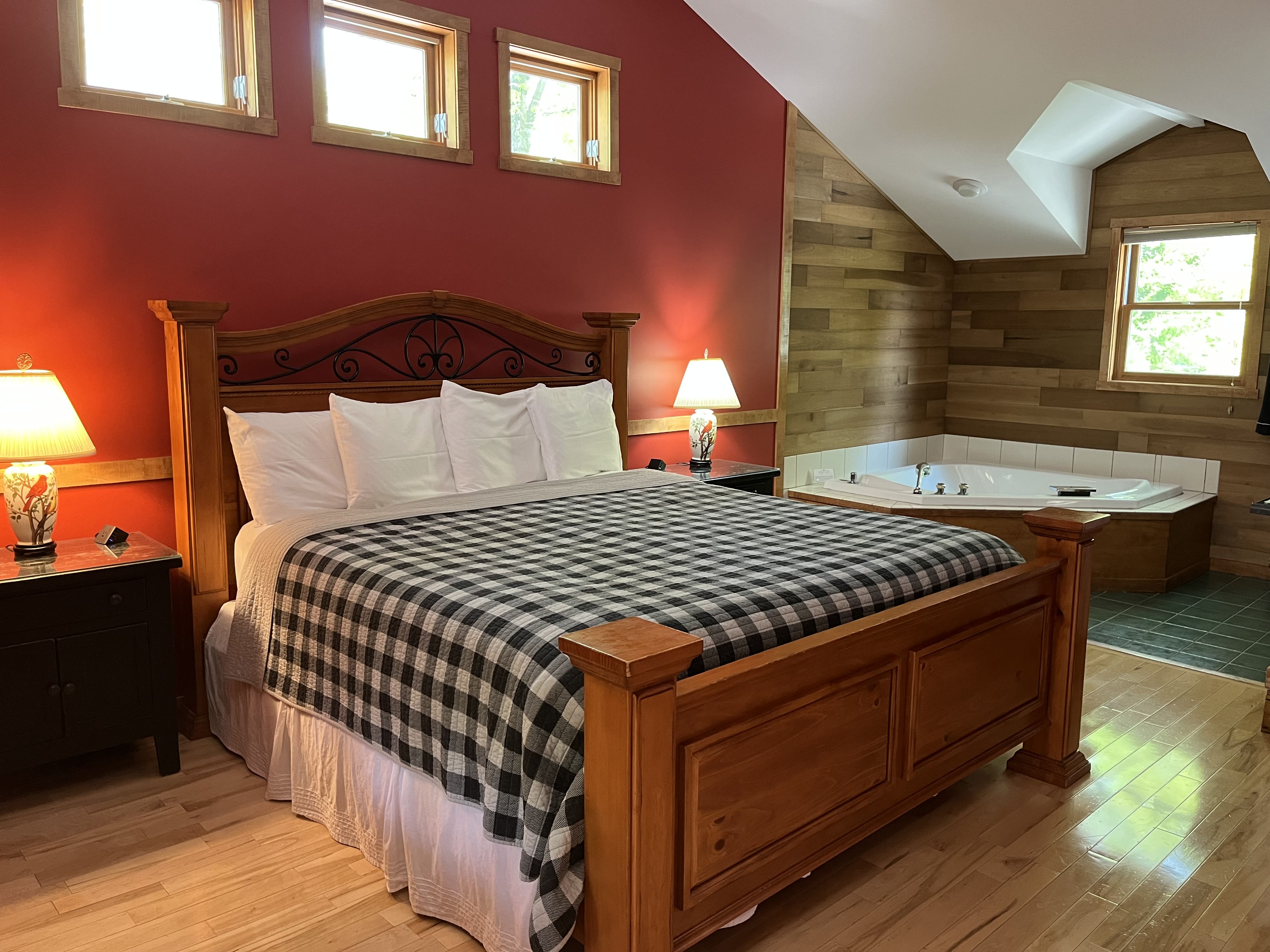 View of King Size bed with double jacuzzi tub and kitchenette in backgroud