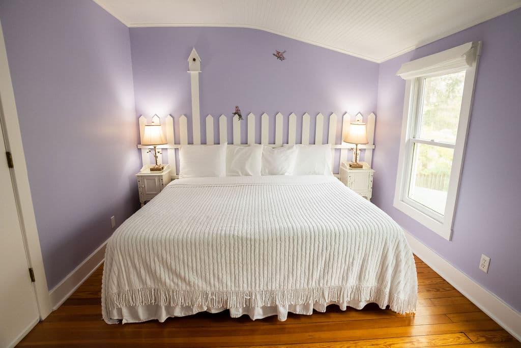 View of king size bed with lights on nightstands on both sides