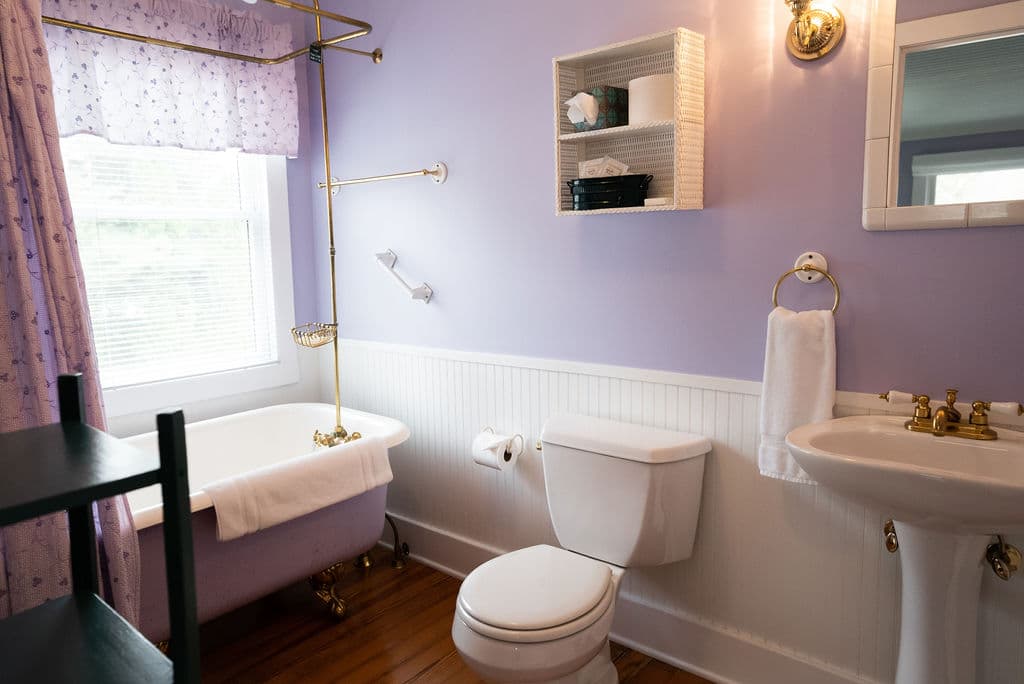 View of bathroom with clawfoot tub, pedestal sink and toilet