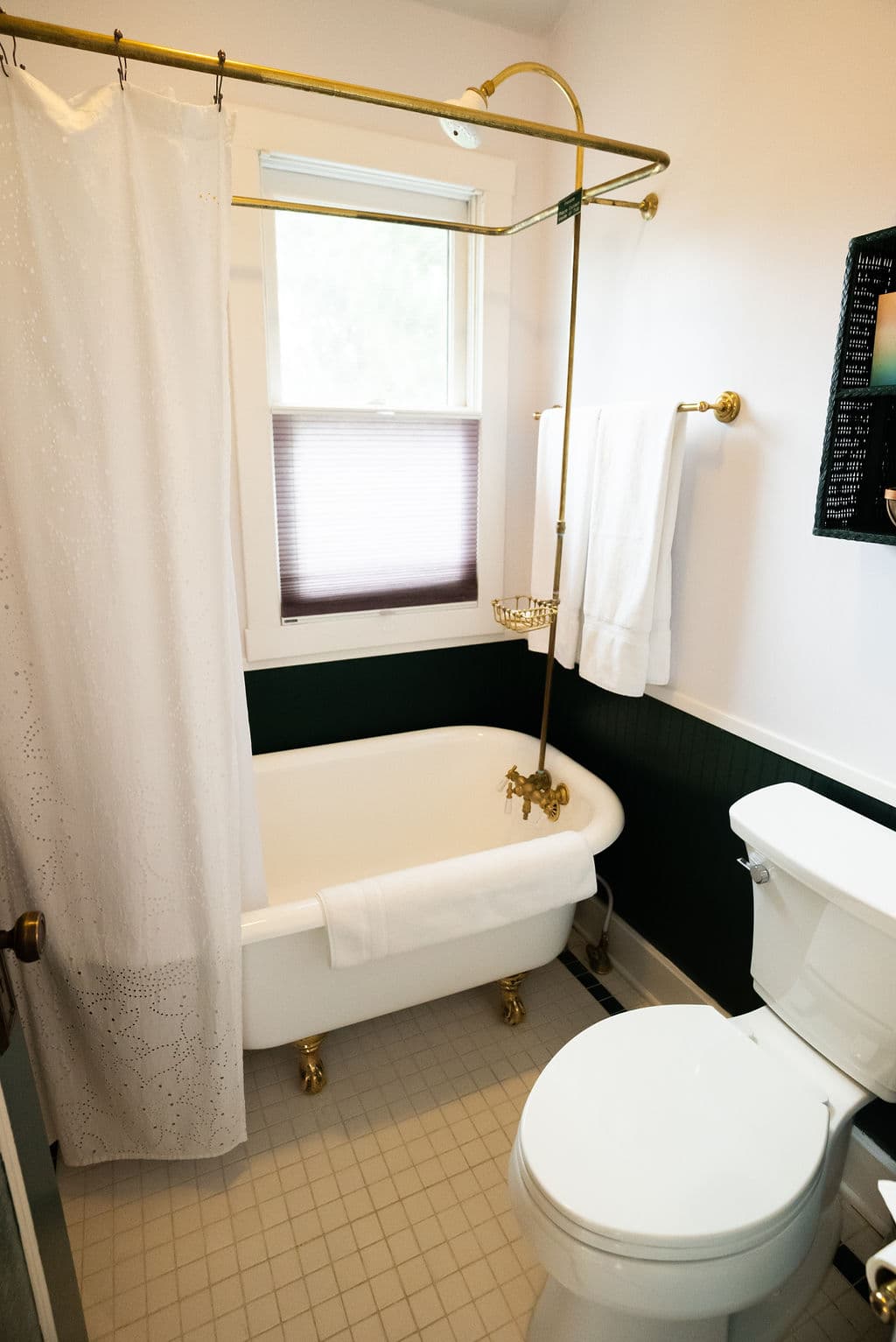Clawfoot tub/shower with towels, window and toilet