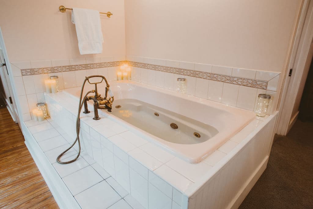 Double jacuzzi flanked with flameless candles and twinkle lights