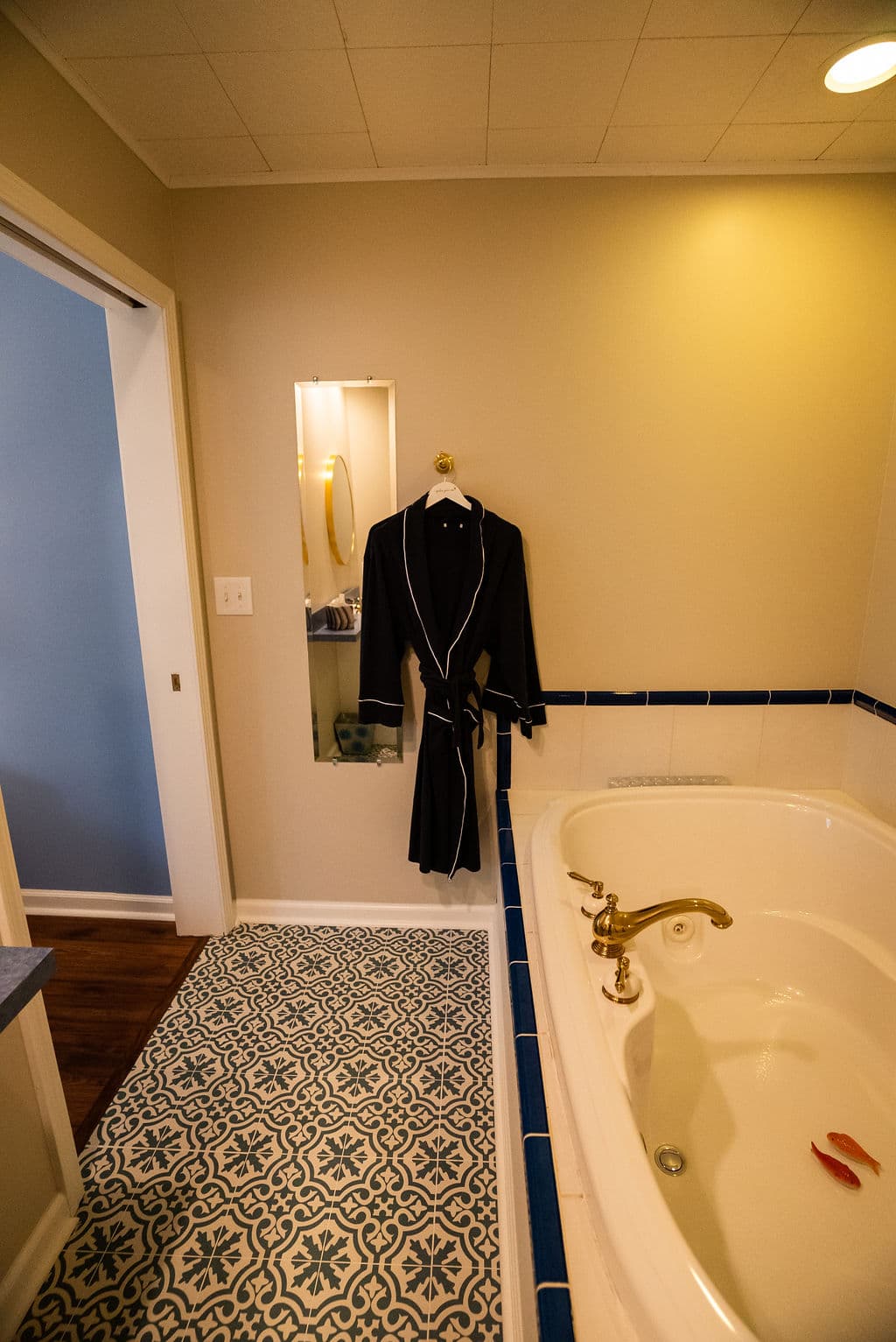 Double jacuzzi tub and bathrobes hanging by door