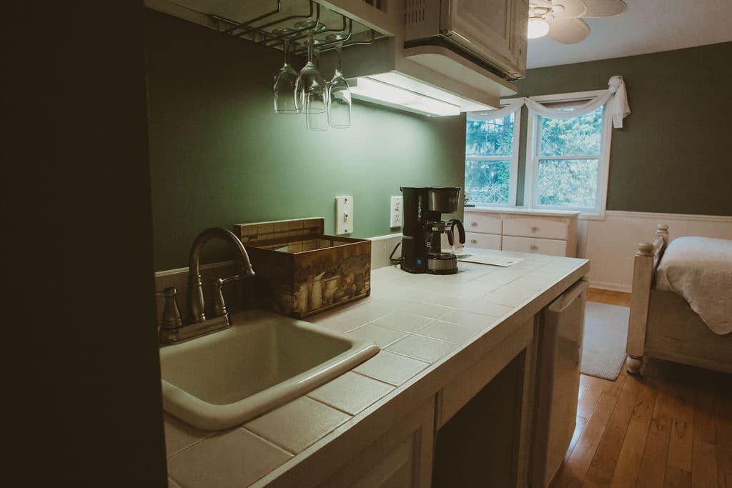 Kitchenette that includes dishes, coffee maker, sink, microwave and mini fridge