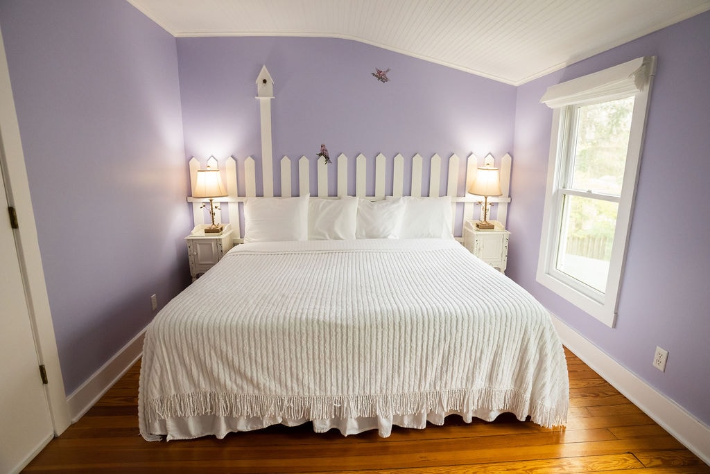 View of king size bed with lights on nightstands on both sides