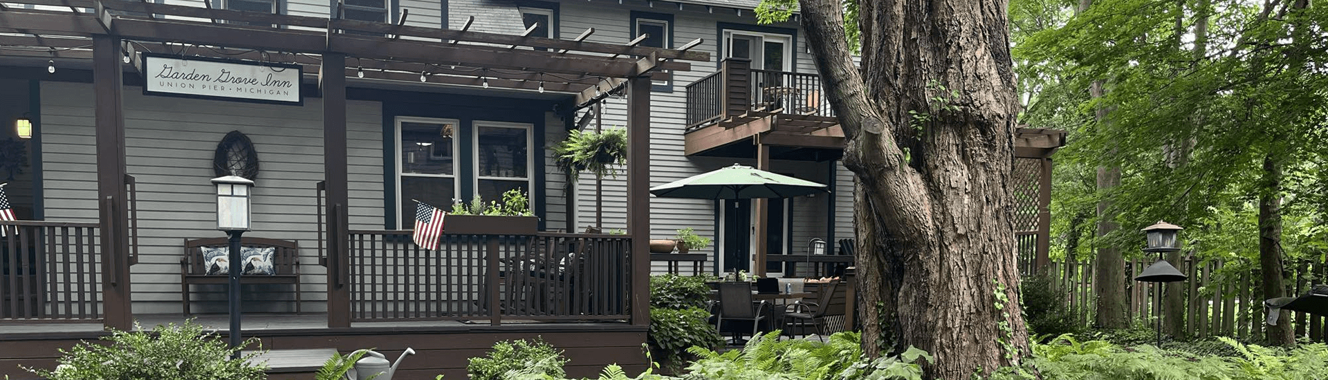 A charming inn with outdoor seating surrounded by lush greenery.