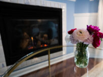 Bouquet of fresh spring flowers on table in front of fireplace.